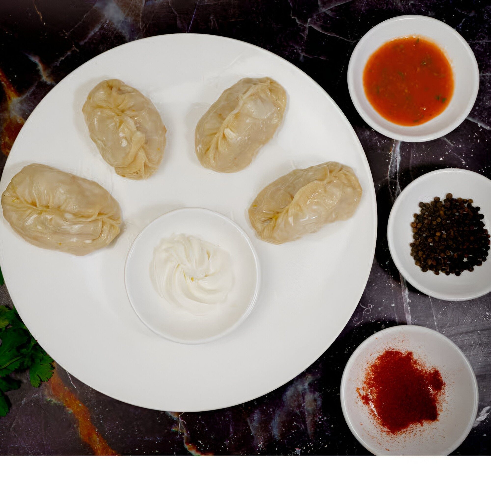 A plate of manti dumplings with sauces
