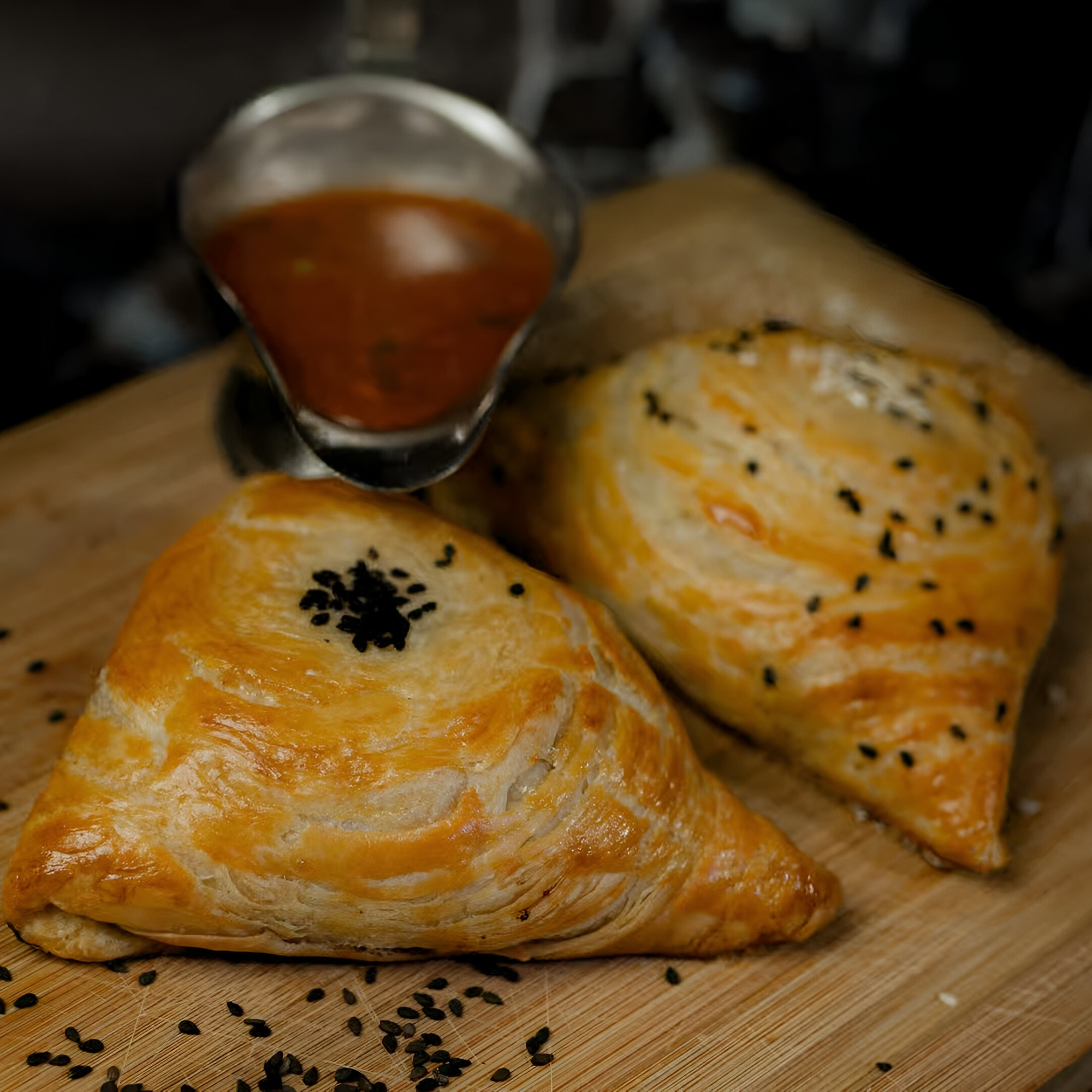 Golden sambusa pastries served on a wooden board